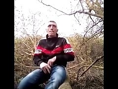STRIP OFF NAKED IN THE WOODS SIT ON A TREE AND WANK MY BIG DICK AND SHOOT MY CUM