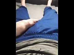 A guy in blue sweatpants rubs his bulge