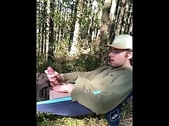 Jerking off in a hammock in the forest.